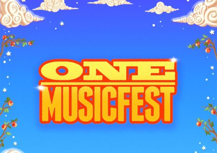 ONE MUSICFEST logo over a whimsical fantasy landscape with a yellow brick road and a city in a glass dome