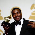 Rodney Jerkins smiles and holds a GRAMMY Award