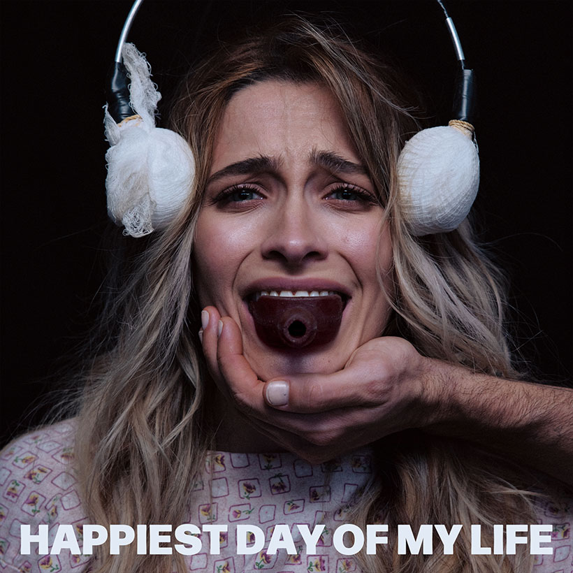 A distressed Paris Jackson with bandaged ears under headphones and a gag in her mouth, held by a hand, with text reading Happiest Day of My Life