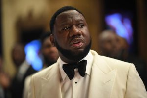 Pierre "P" Thomas wearing a cream tuxedo jacket and black bow tie, looking off to the side