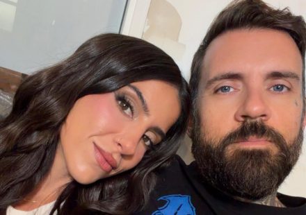 Lena the Plug smiling with long dark wavy hair leaning close to her husband Adam22 with blue eyes